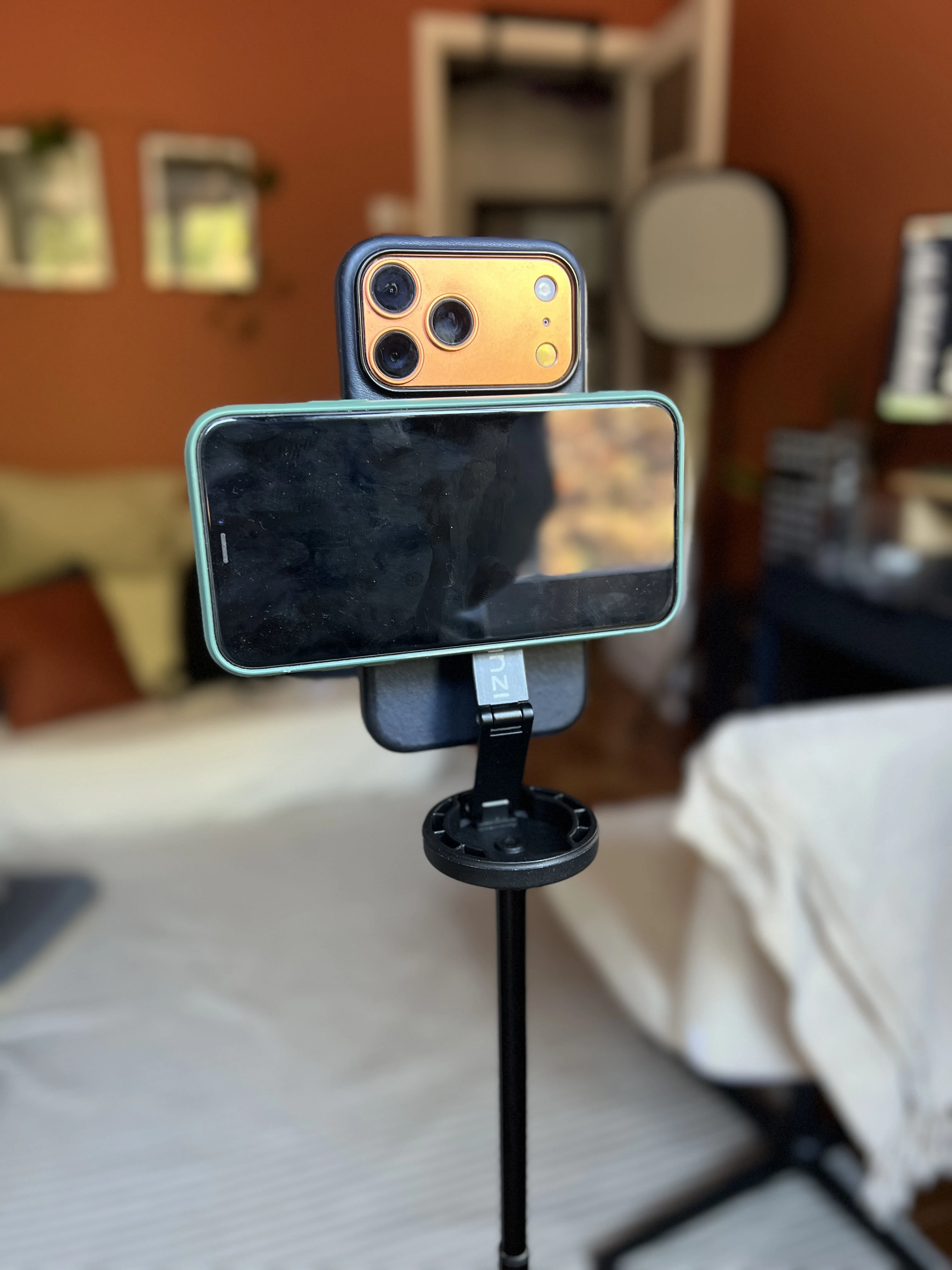 Our actual two-iPhone Teleprompter setup: landscape reader mounted directly below the filming camera lenses, supported by the slim bracket and stand